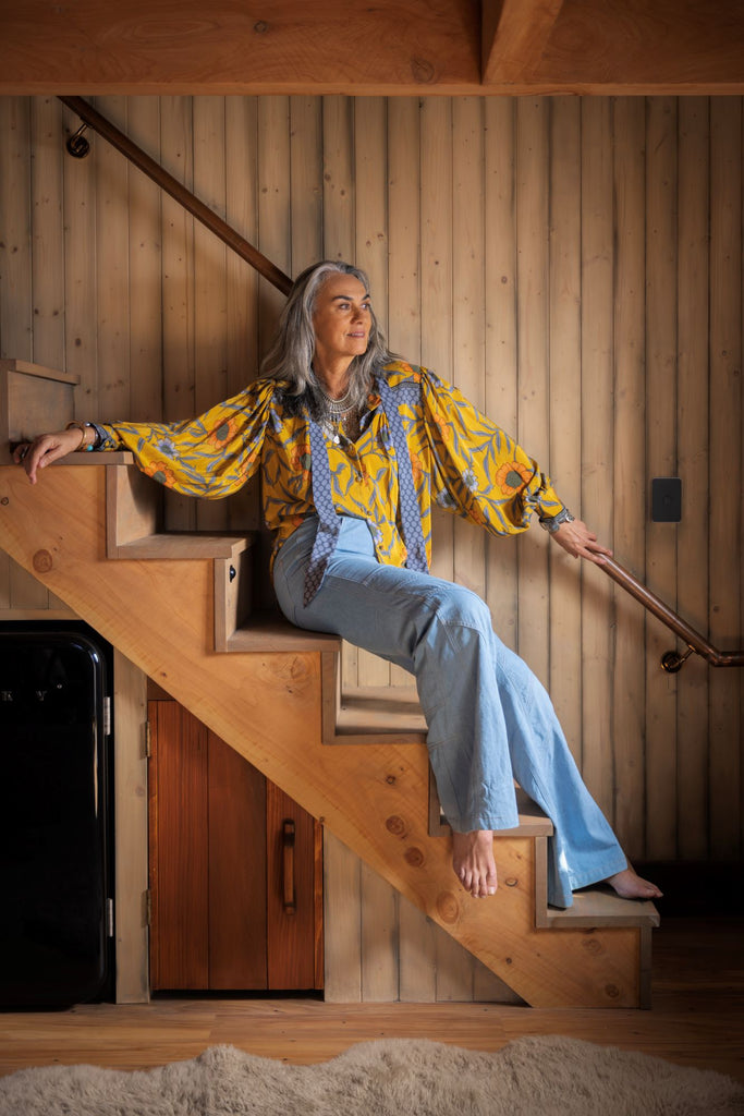 woman sitting on steps in yellow birkin blouse